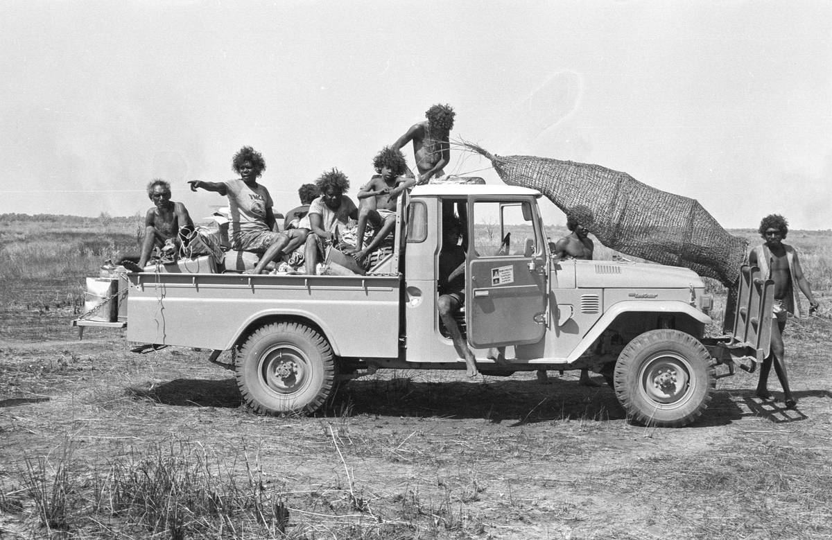 A utility vehicle transports a conical fish trap and family members to Maningrida